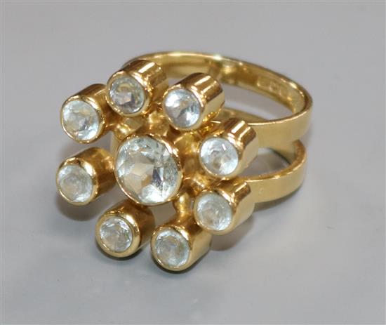 A modern 18ct gold and aquamarine stylised flower head cluster ring, size M/N.